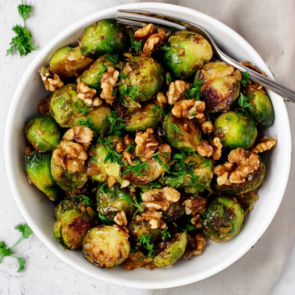 Close-up captures the maple glaze clinging to roasted Brussels sprouts and crunchy walnuts, a perfect bite.