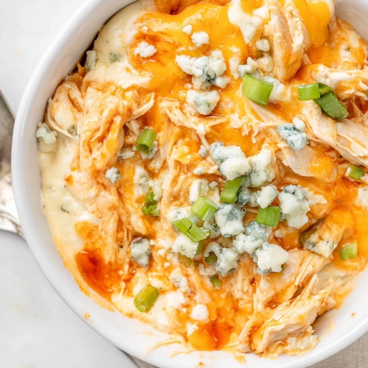 Close-up of Buffalo Chicken Dip, cheesy and flavorful, served warm at a game-day party.