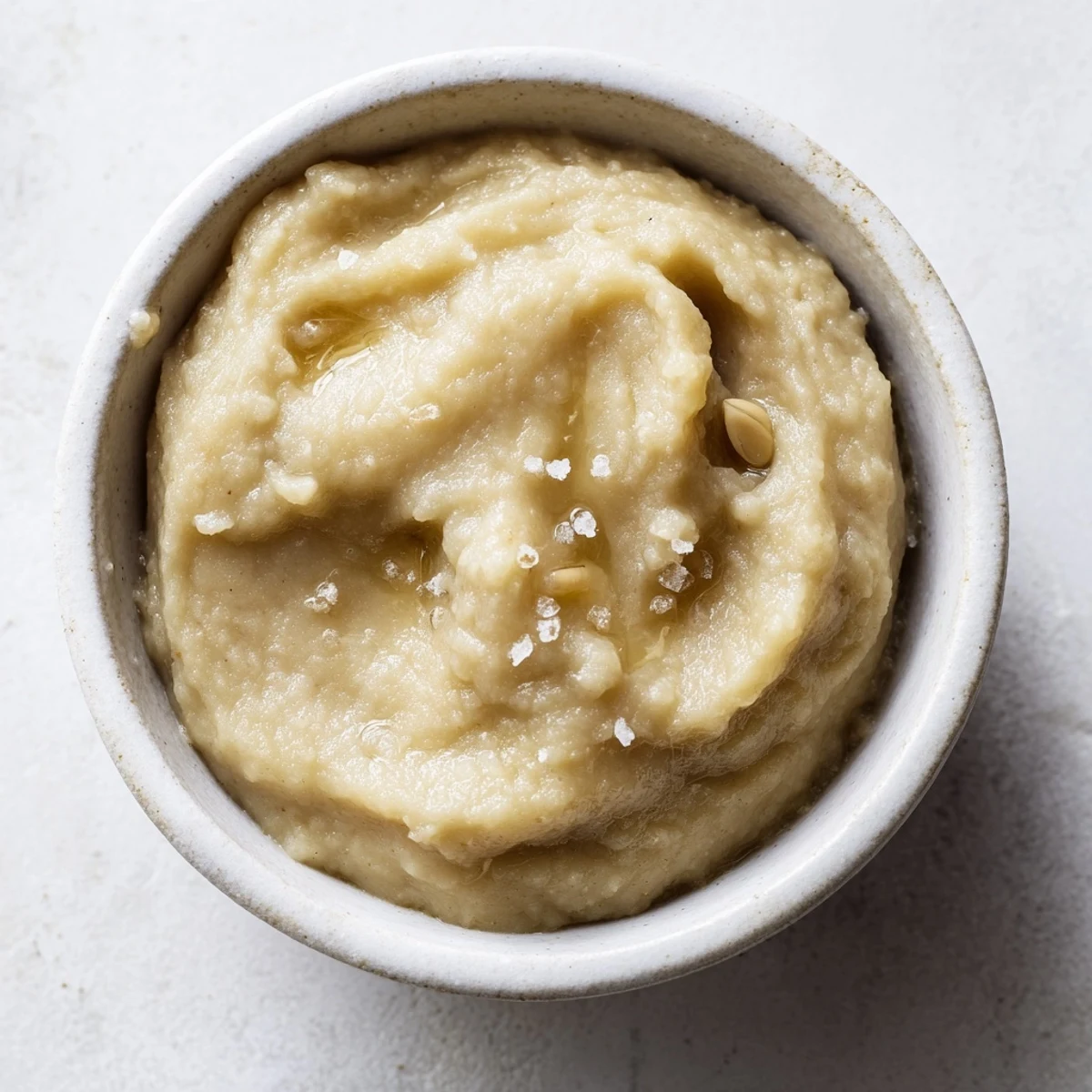 Homemade garlic crusher, a vibrant paste with a hint of olive oil, perfect for dipping.