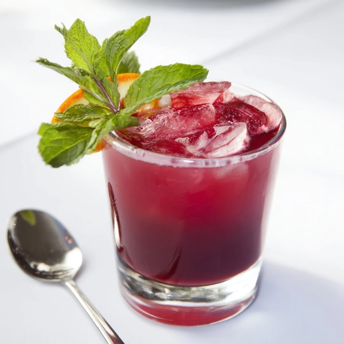 A refreshing glass of Cranberry Fresh, a vibrant drink with floating cranberry garnishes.