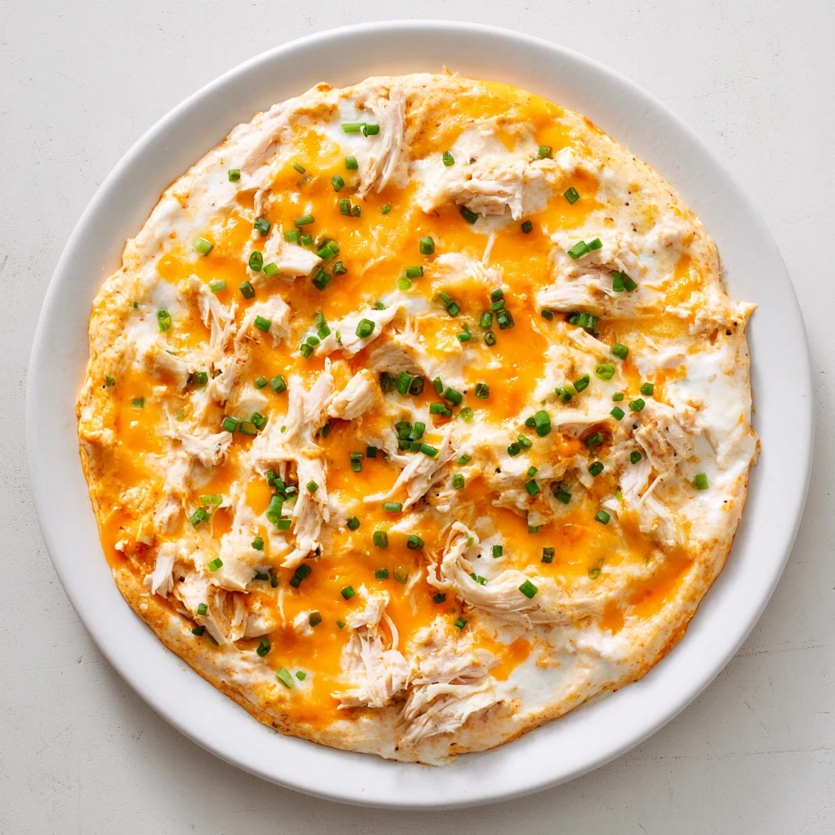 A close-up of creamy, flavorful Spicy Buffalo Chicken Dip, ready to scoop with flavorful dippers at a party.