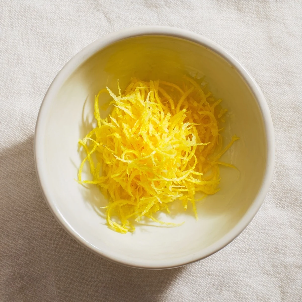 Close-up of bright yellow lemon zest, ready to use in baking or as a zesty garnish.
