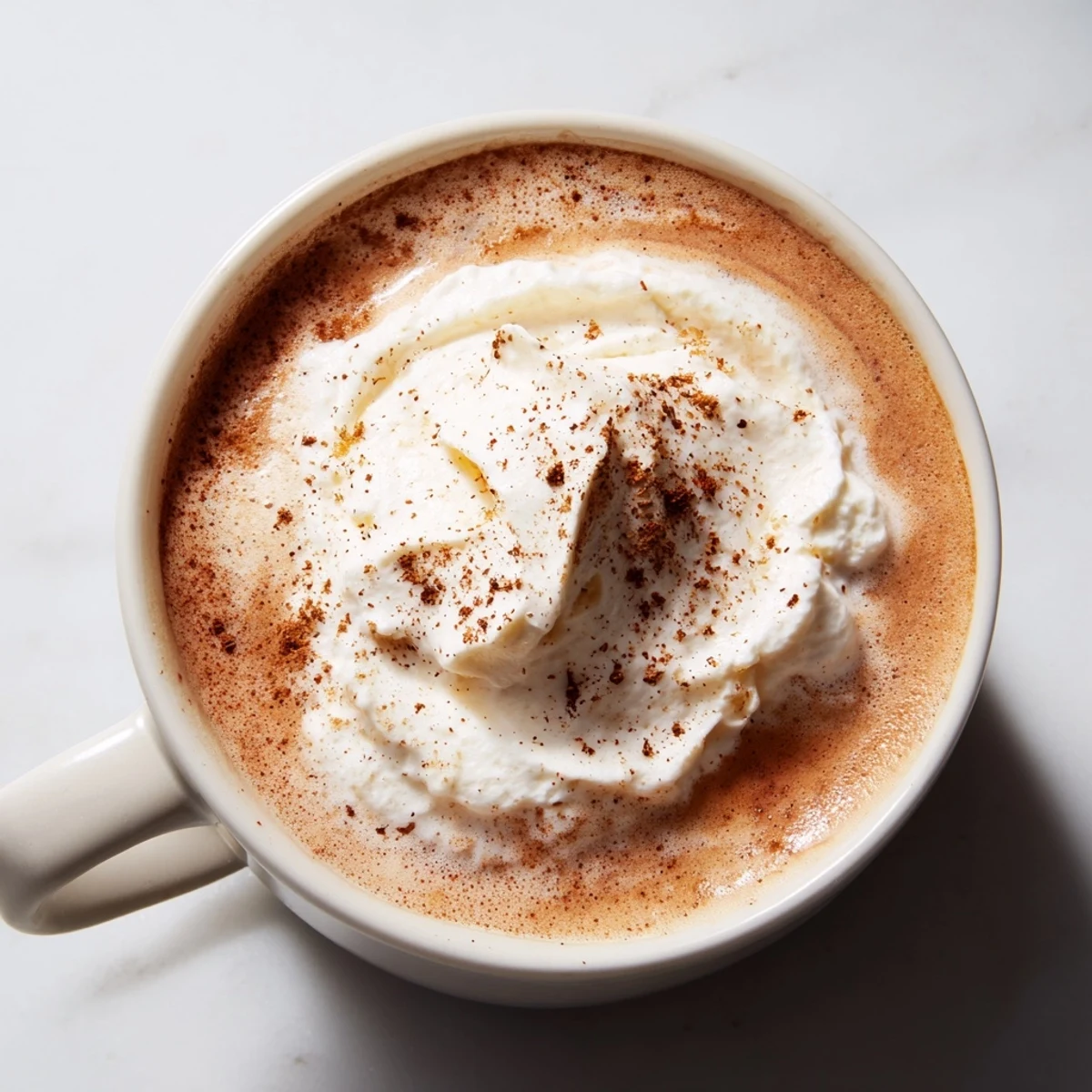 Enjoy a homemade Spiced Latte, a flavorful coffee drink with cinnamon and nutmeg on top.