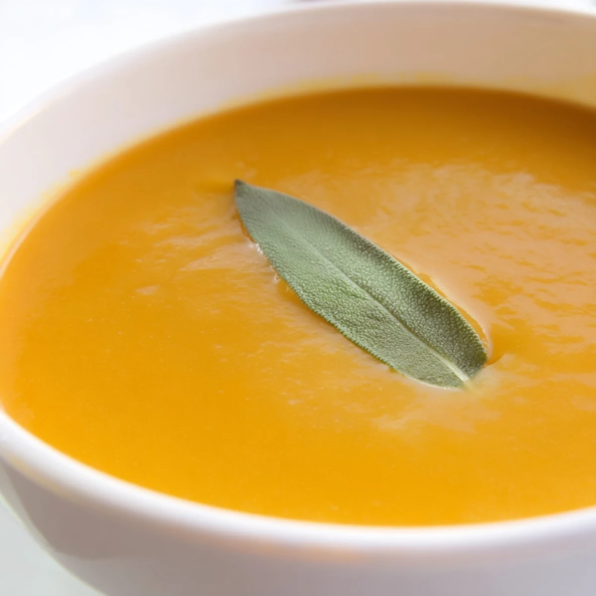Silky butternut squash and apple soup topped with crispy sage and a drizzle of cream.