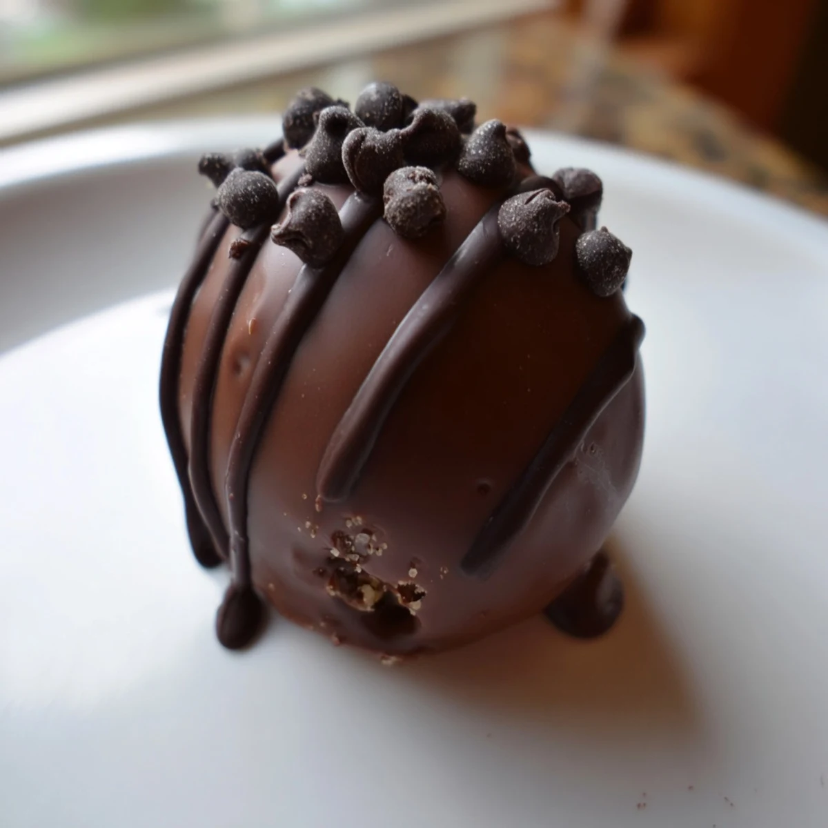 These Chocolate Chip Cookie Dough Truffles are dusted with cocoa powder and arranged neatly on a cooling rack.