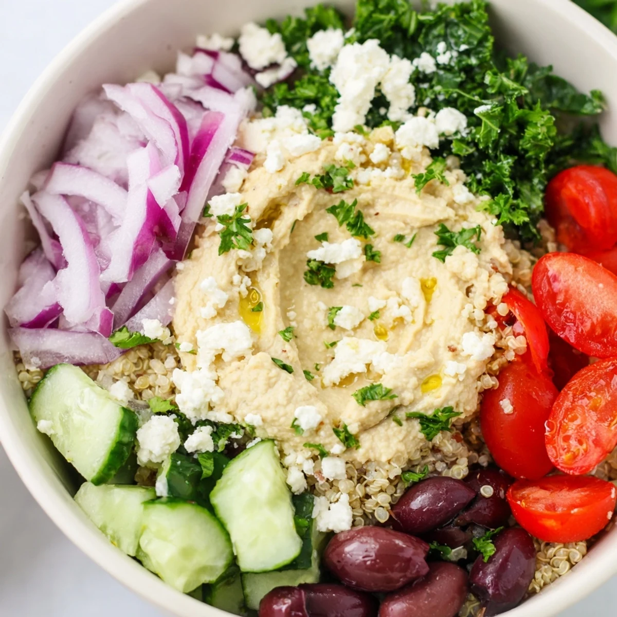 Colorful Mediterranean Quinoa Bowl with Hummus, perfect for meal prep, garnished with parsley and roasted red peppers.