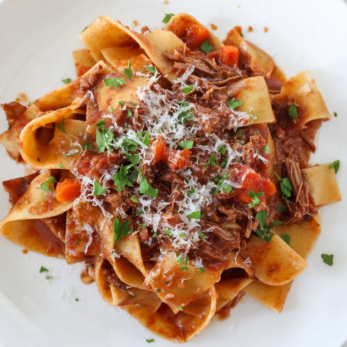 Shredded tender beef simmered in a rich tomato sauce with Pappardelle pasta, ready to serve for a hearty family dinner.