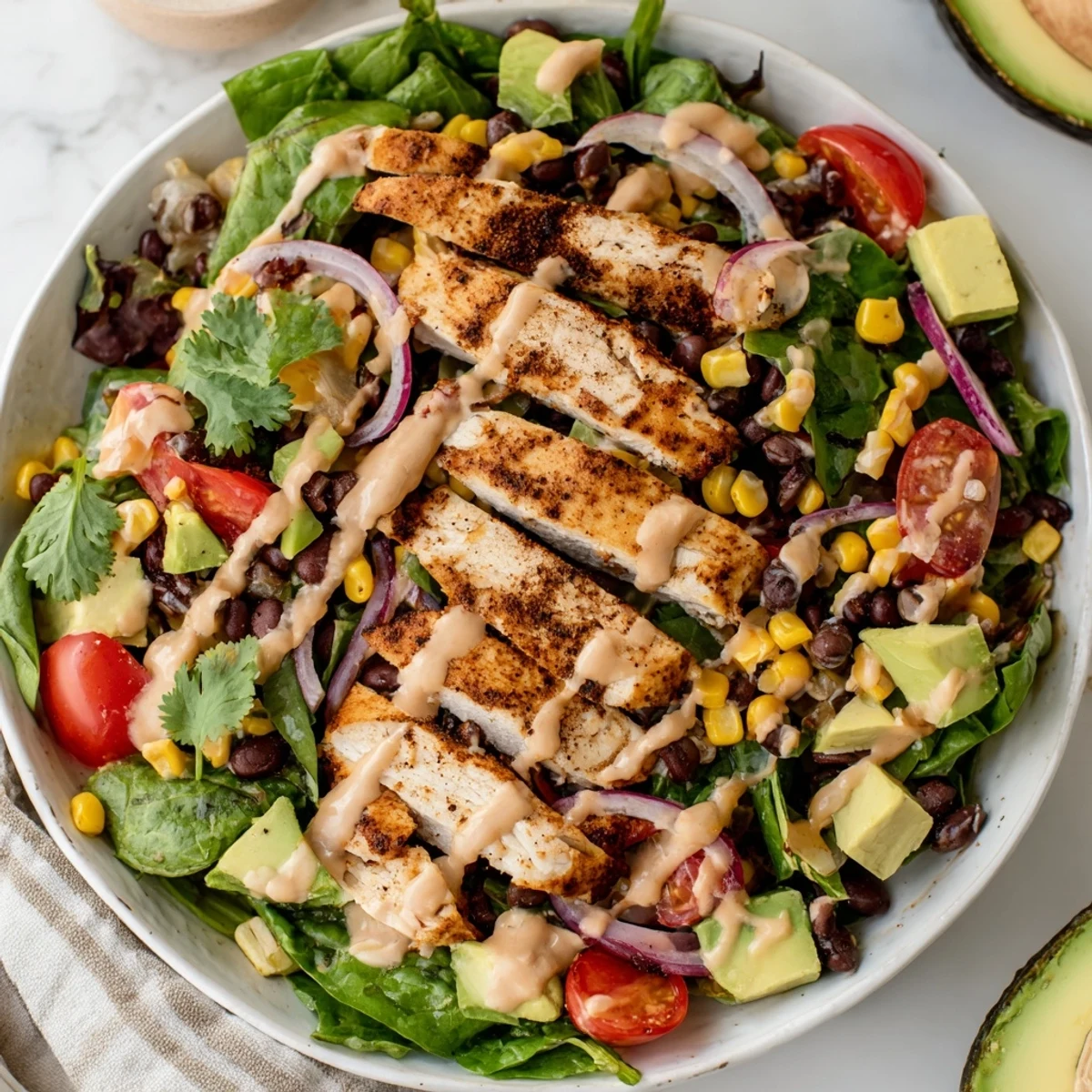 Vibrant Southwest Chicken Salad garnished with fresh cilantro and red onion, served on a white plate with a lime wedge on the side.