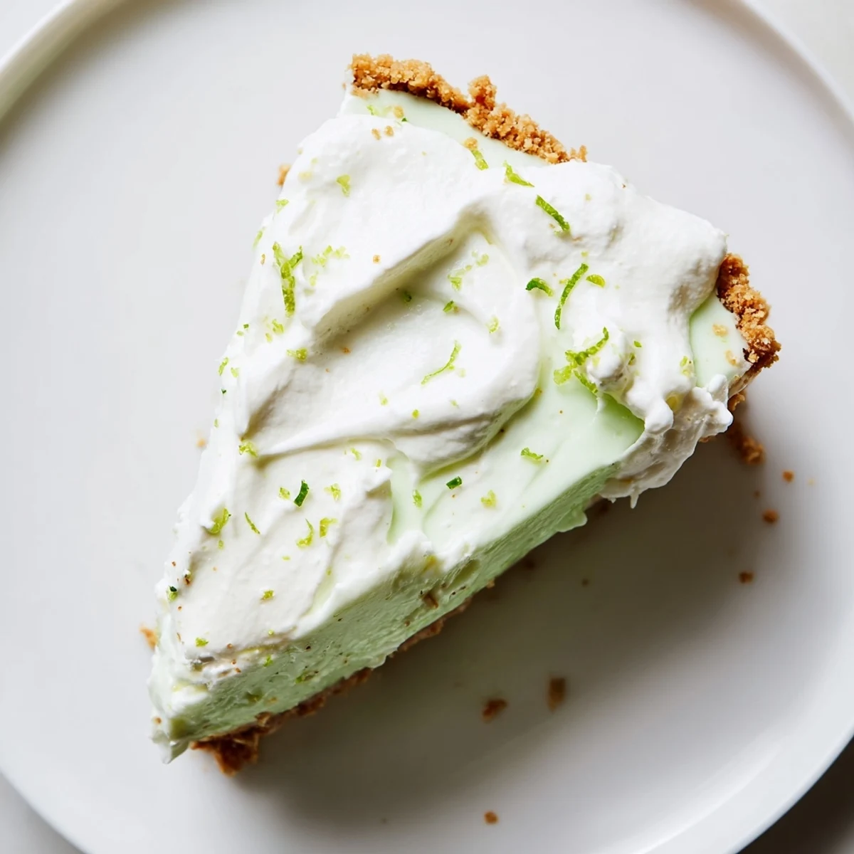 Freshly baked Key Lime Pie with whipped cream topping, showcasing its creamy texture and graham cracker crust.  