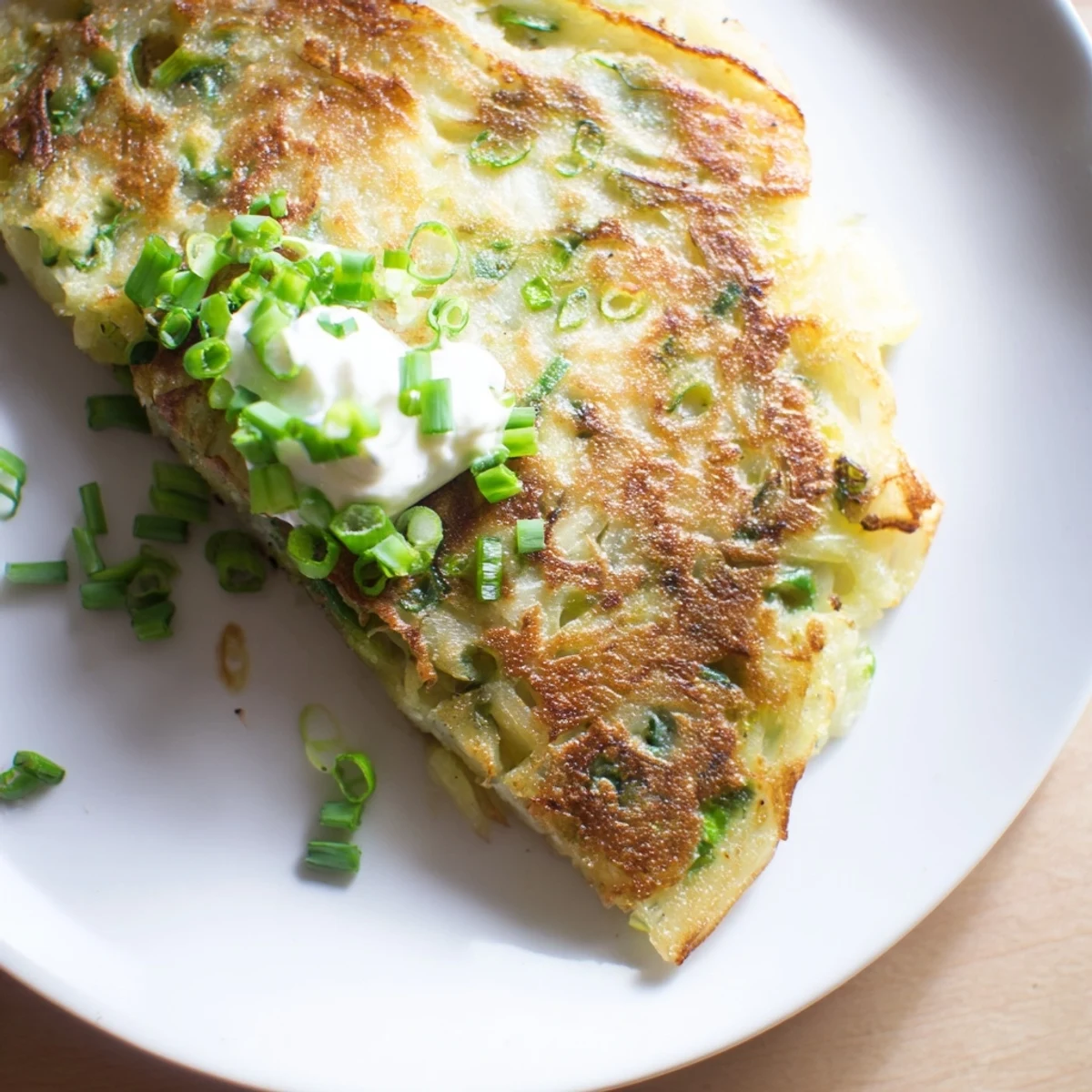 A platter of Irish Boxty Potato Pancakes with Scallions served with a dollop of sour cream and fresh chives on the side. 