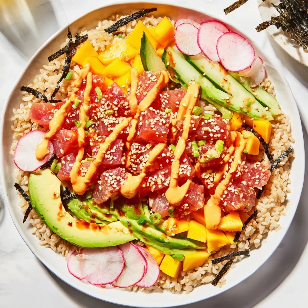 Overhead view of a Hawaiian-style Spicy Tuna Poke Bowl with mango, avocado, and spicy tuna over rice.
