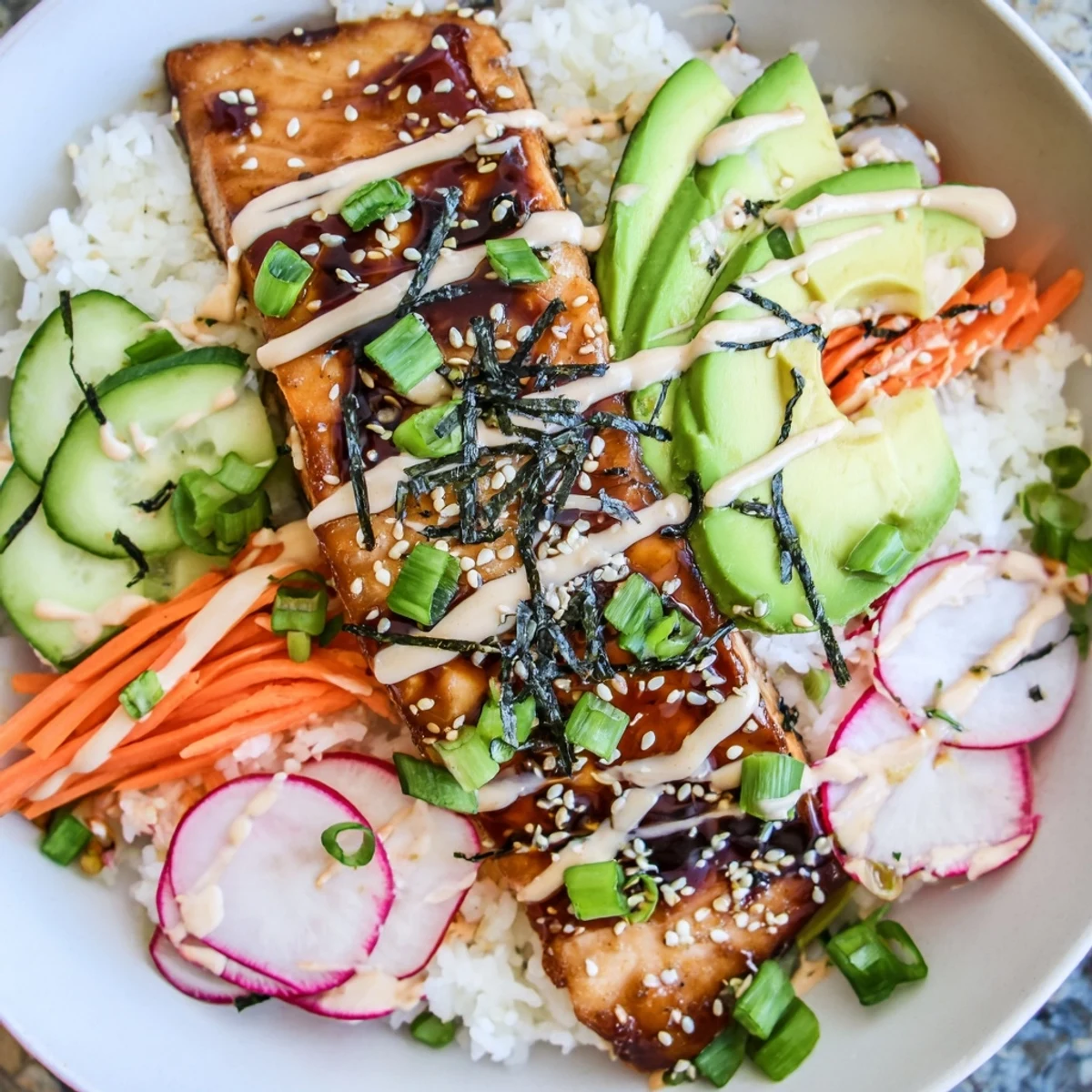 Tender teriyaki-glazed salmon on fluffy jasmine rice, topped with crunchy pickled veggies and sriracha mayo in a vibrant bowl.