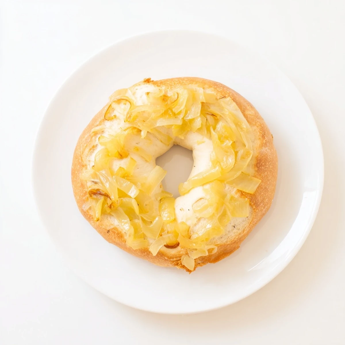 Close-up of a sliced Sourdough Onion Bagel revealing a soft crumb and savory onion topping, ready for toasting.