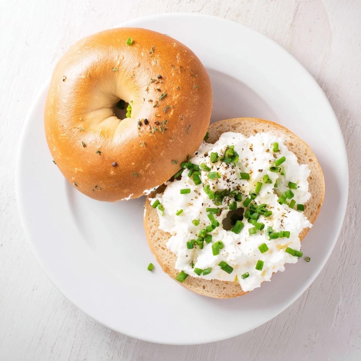 Soft, whole wheat Protein Bagels with Cottage Cheese served on a plate, garnished with black pepper for a savory bite.
