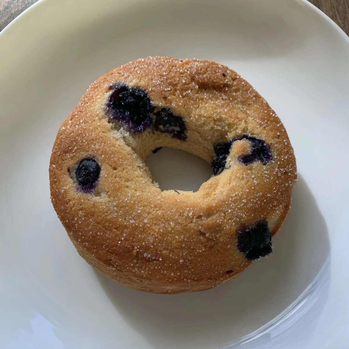 Freshly baked Gluten-Free Blueberry Bagels cooling on a wire rack, golden crust with visible blueberry specks.