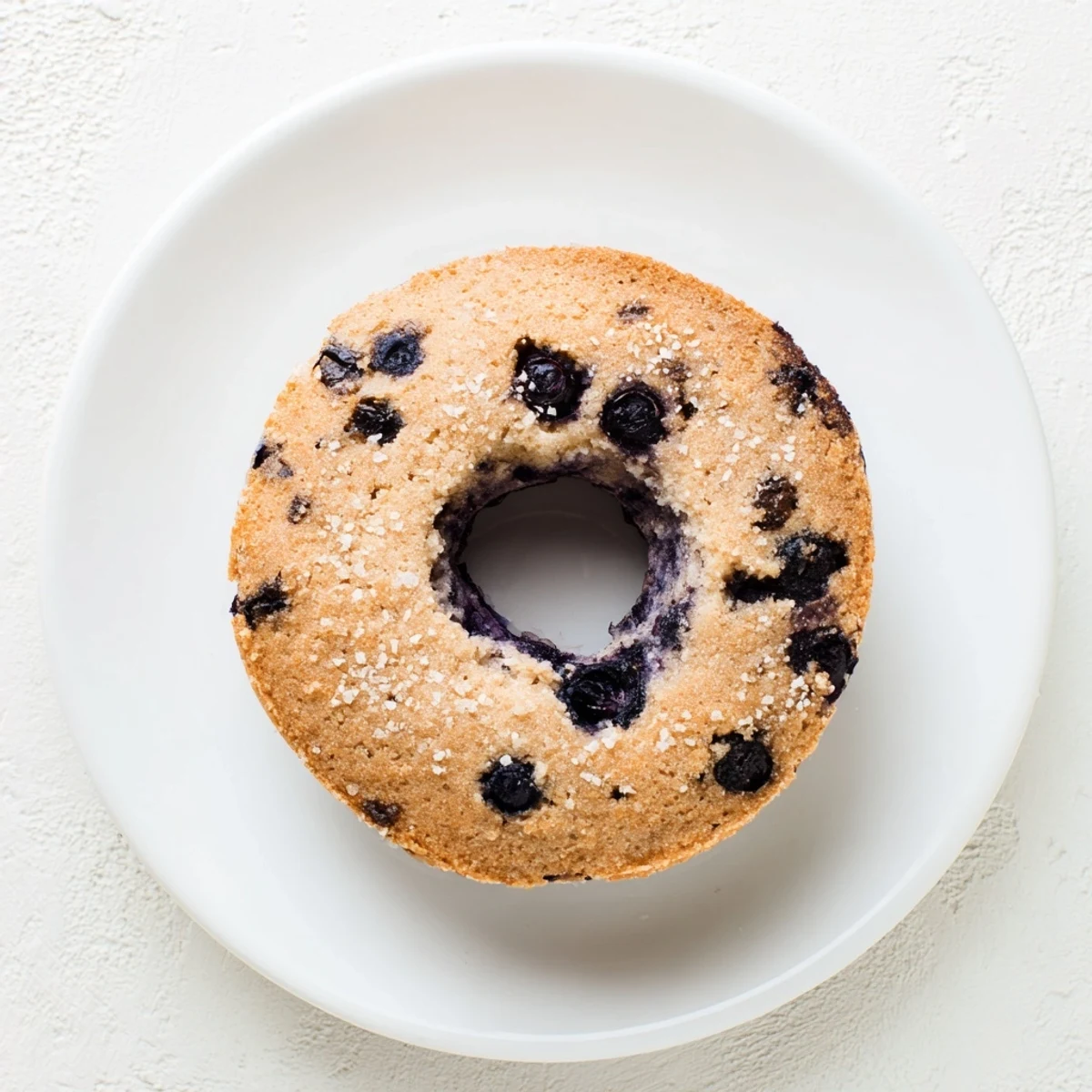 Warm Gluten-Free Blueberry Bagels on a wooden board with cream cheese spread, ready for a cozy breakfast.