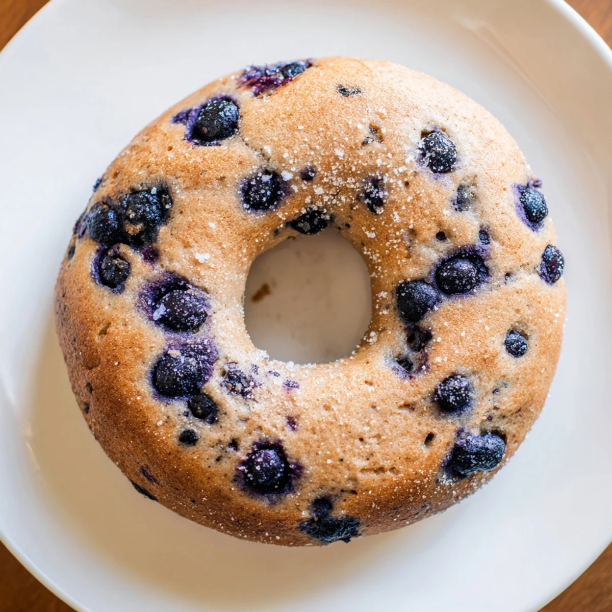 Overhead view of Gluten-Free Blueberry Bagels on a baking sheet, showing their chewy texture and sweet berry pockets.