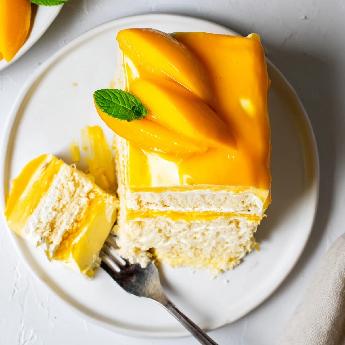 Elegant mango mousse cake with airy sponge, creamy mango mousse, and a shiny glaze, perfect for summer celebrations.