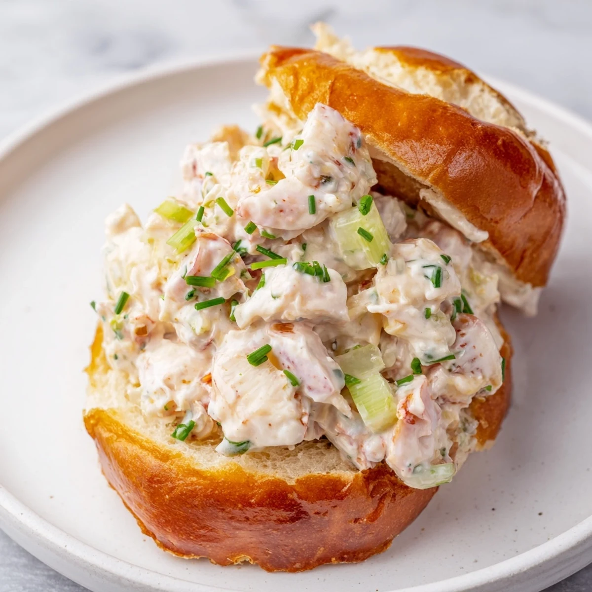 New England style garlic butter lobster rolls stuffed with creamy herbed lobster filling in toasted rolls