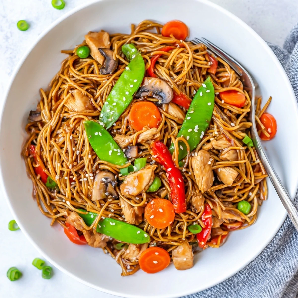 Homemade chicken lo mein piled high with peppers carrots and sesame garnish from the slow cooker