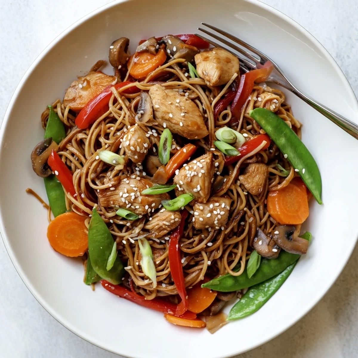 Easy crockpot chicken lo mein tossed with chewy noodles and snow peas in savory soy ginger glaze