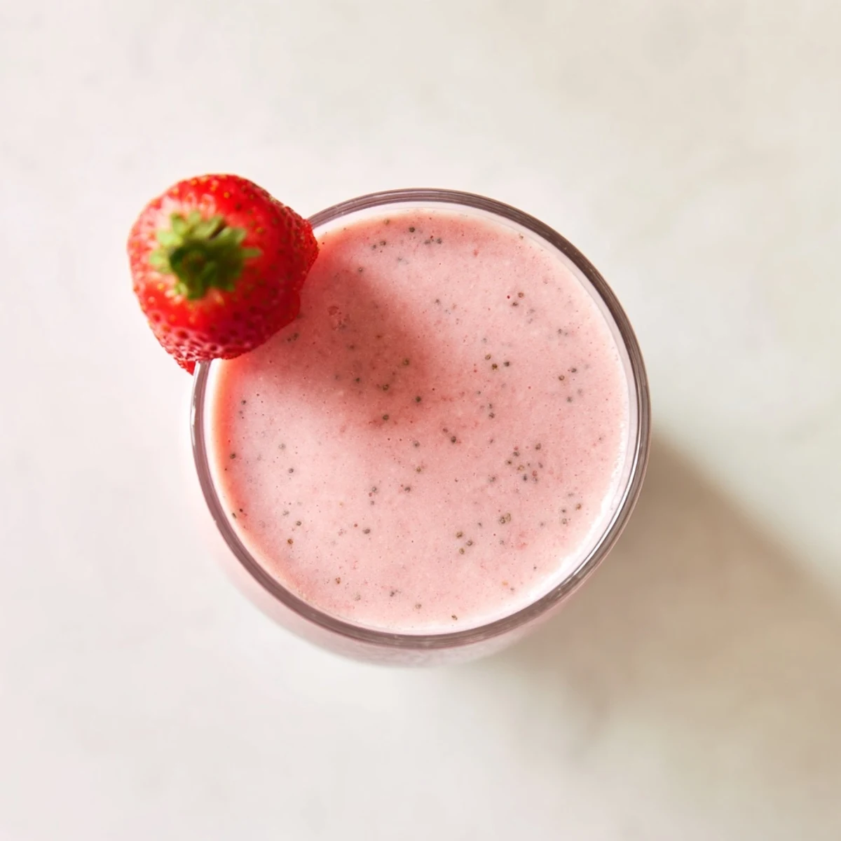 Thick pink strawberry smoothie with Greek yogurt poured into a clear glass
