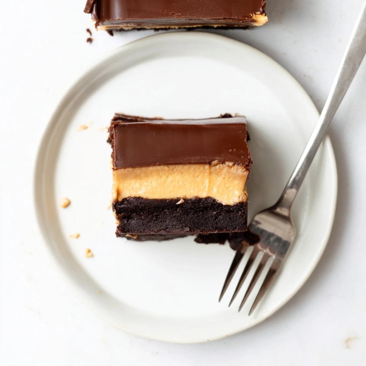 Homemade layered peanut butter brownies featuring fudgy chocolate base topped with creamy peanut butter frosting