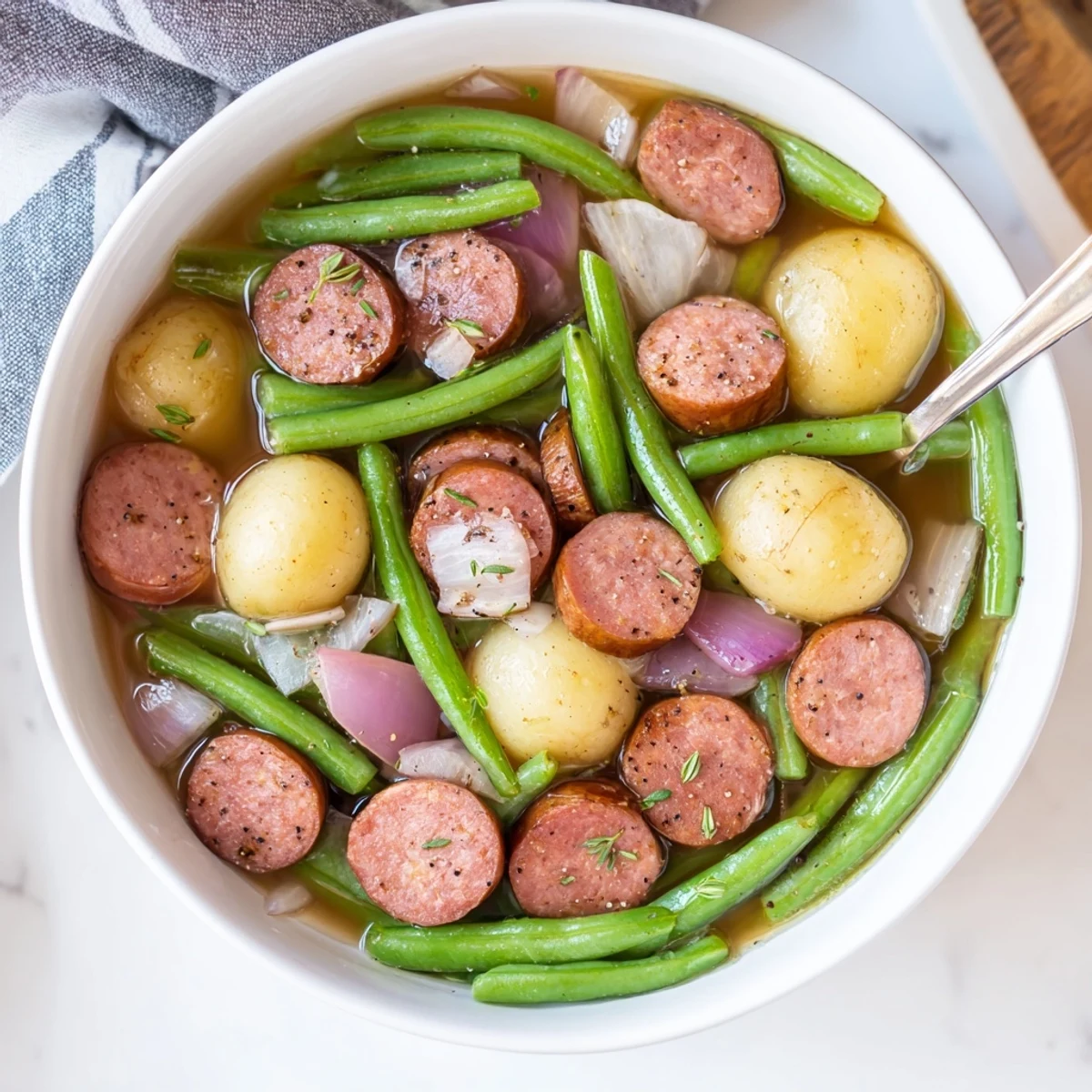 Slow cooker crockpot kielbasa and green beans simmered with tender baby potatoes in savory chicken broth