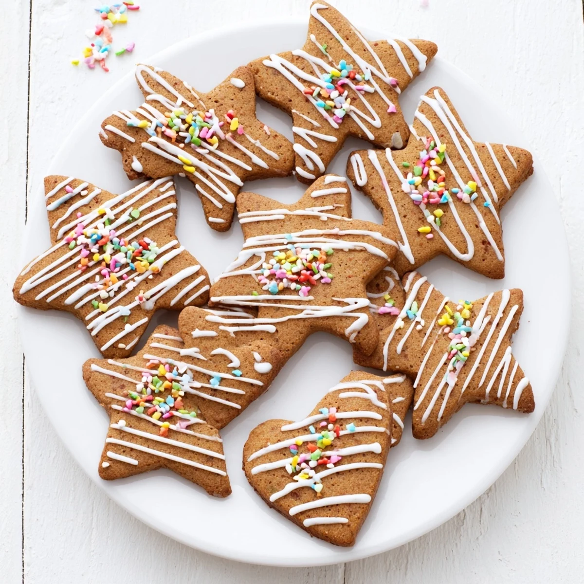 Festive classic cut out gingerbread cookies shaped like stars and hearts topped with piped royal icing details