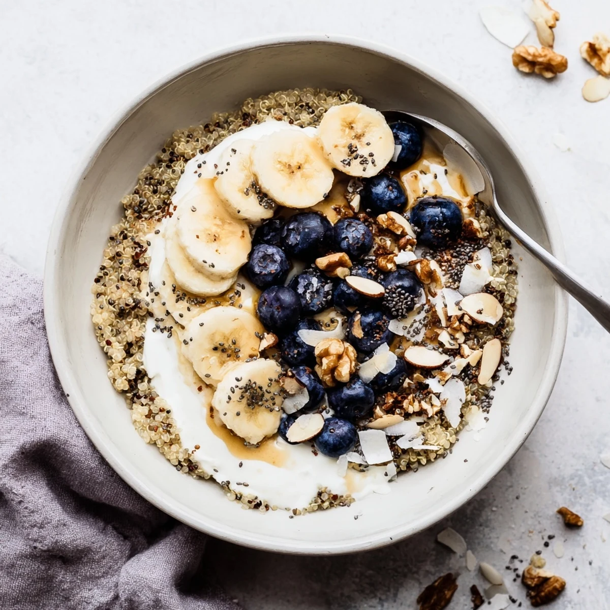 Protein-packed blueberry quinoa breakfast bowl drizzled with honey and sprinkled with walnuts for a nourishing morning meal