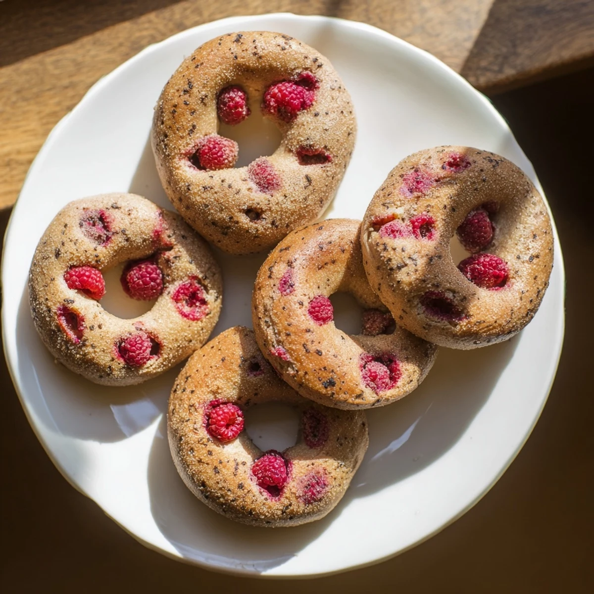 Golden brown raspberry sourdough bagels sprinkled with demerara sugar on a wire rack