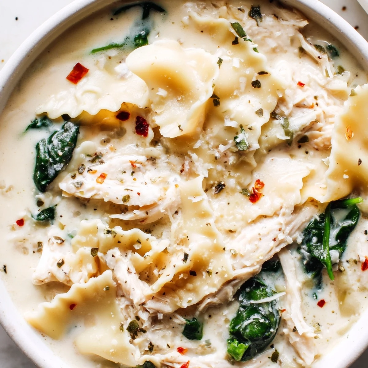 Creamy white lasagna soup in a white bowl with melted cheese and tender noodles