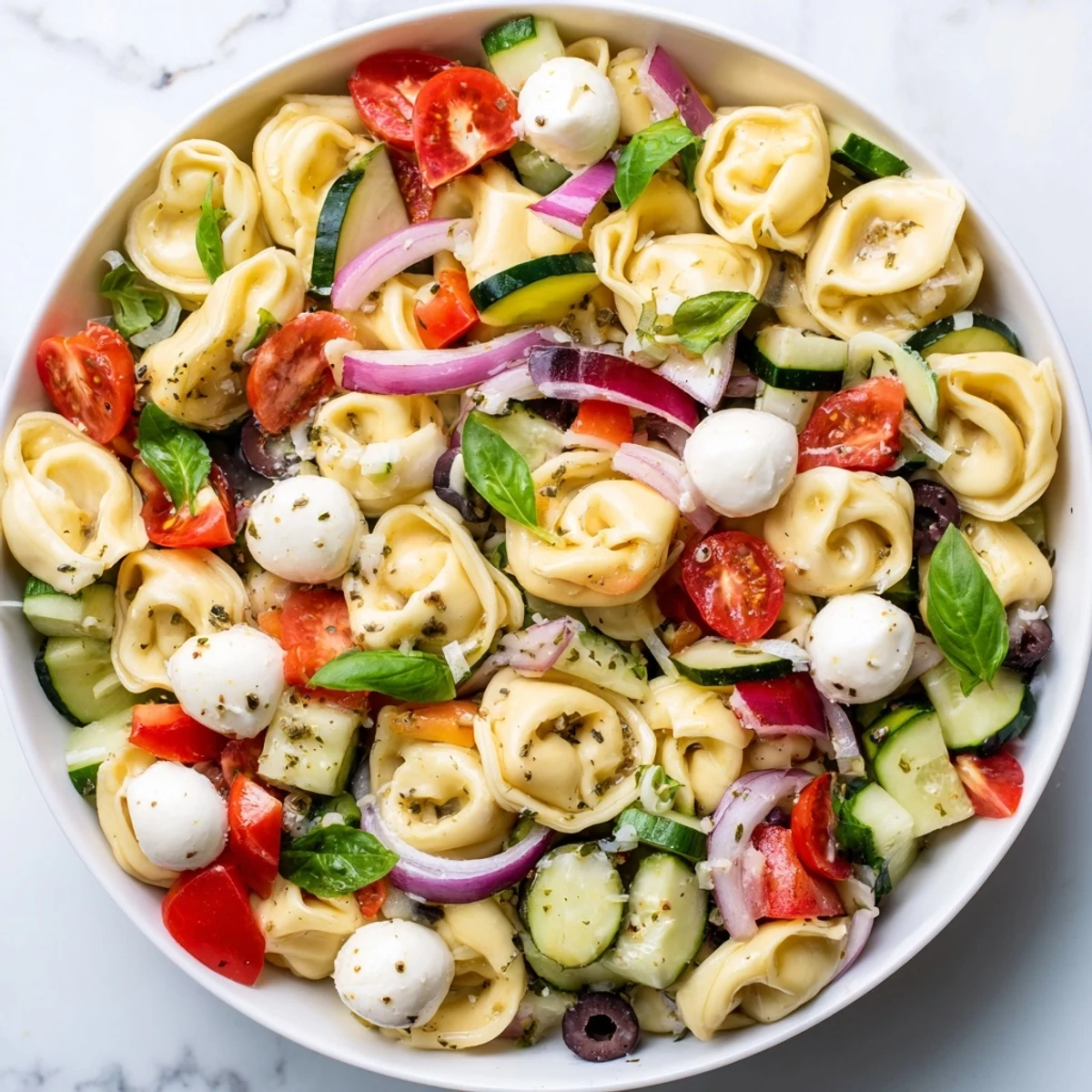 Colorful tortellini salad with crisp vegetables and zesty Italian dressing in a rustic serving bowl