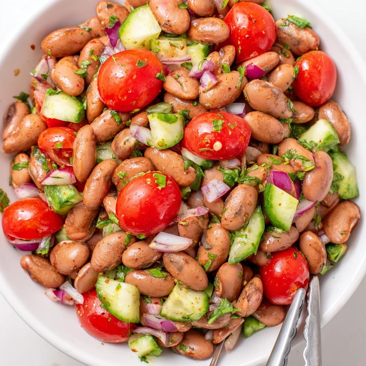 Colorful pinto bean salad with fresh tomatoes and zesty lime dressing in a bowl