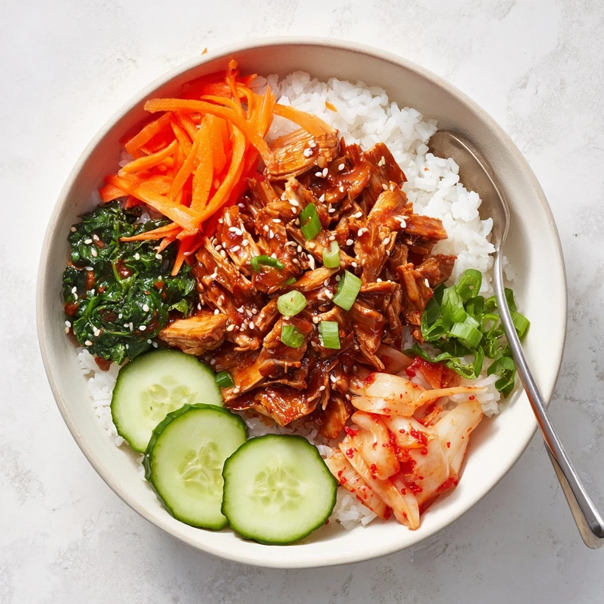 Golden crispy tofu bulgogi bowl topped with julienned carrots, cucumber, and sesame seeds