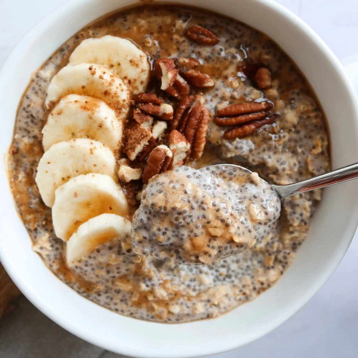 Brown Sugar Coffee Overnight Oats topped with sliced banana and toasted pecans