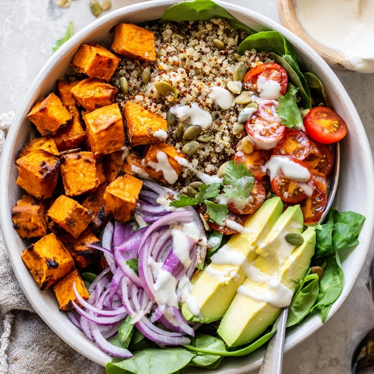 Weeknight Roasted Sweet Potato Quinoa Salad Bowl served warm over greens, sprinkled feta