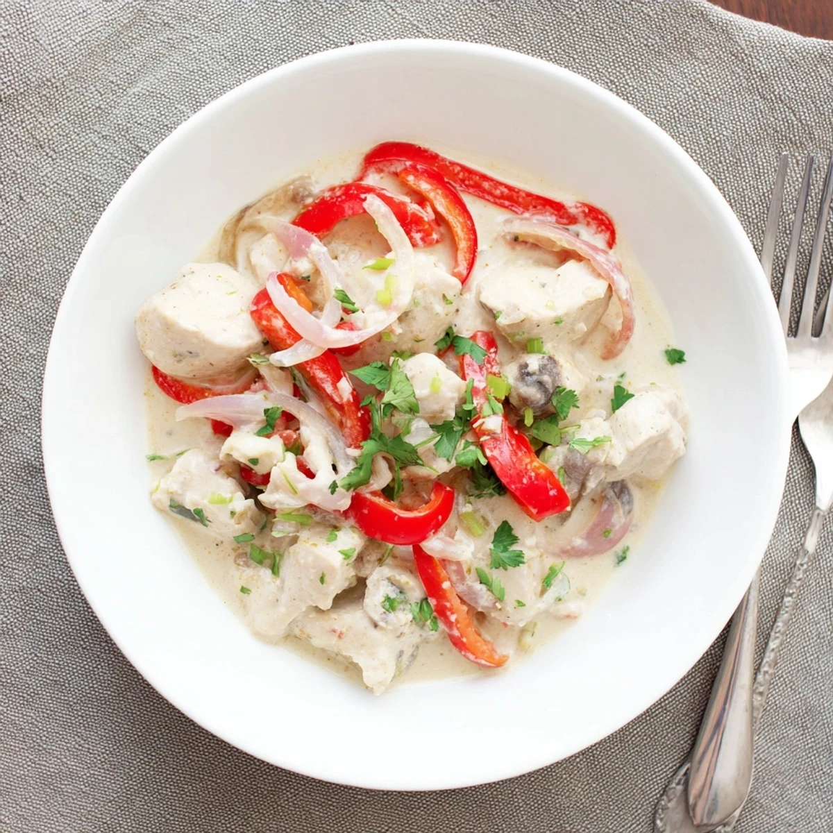 Tender chicken simmered in aromatic white coconut sauce seasoned with cumin paprika and fresh cilantro garnish