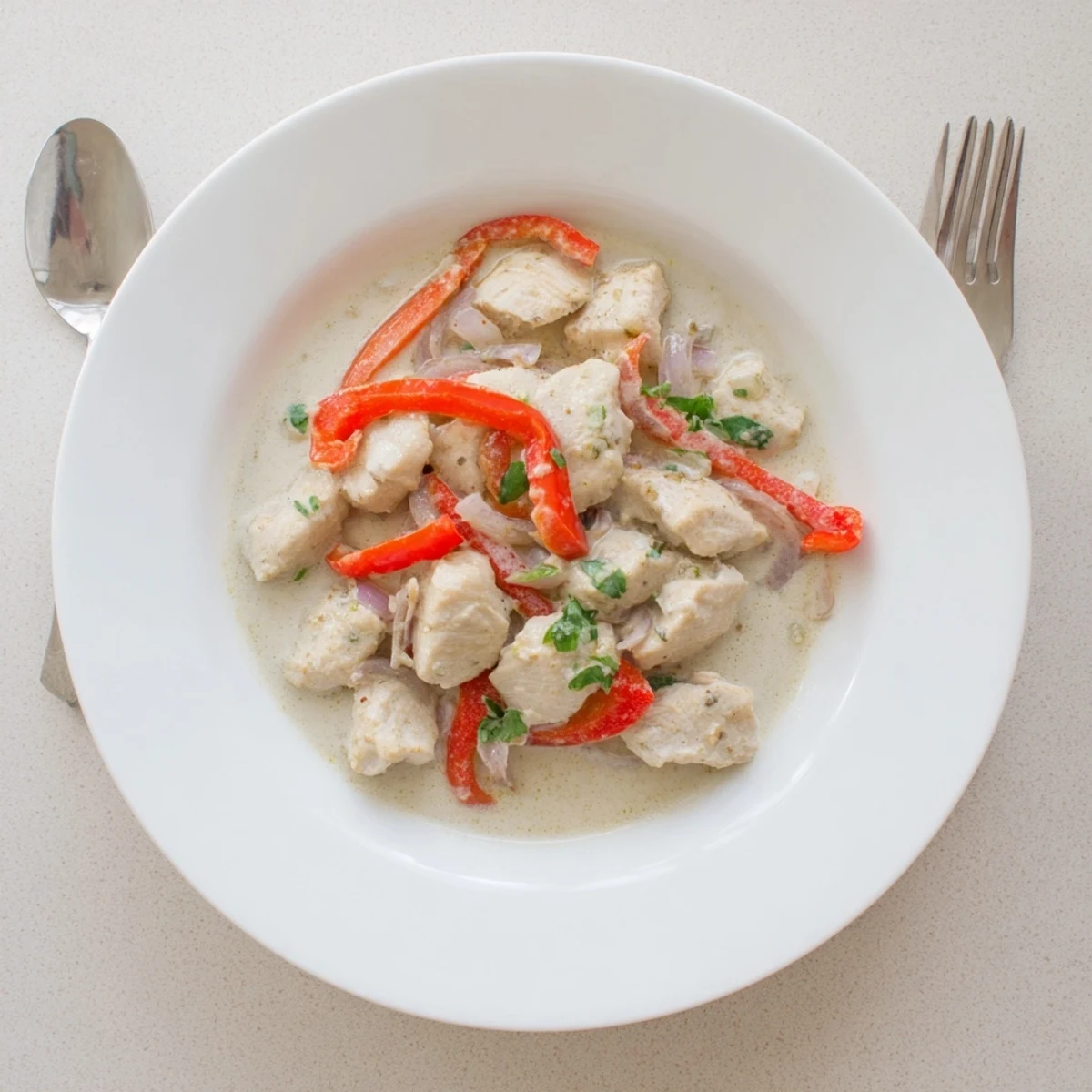 Creamy Brazilian chicken dish with tender meat bites in thick coconut milk sauce served over steamed white rice
