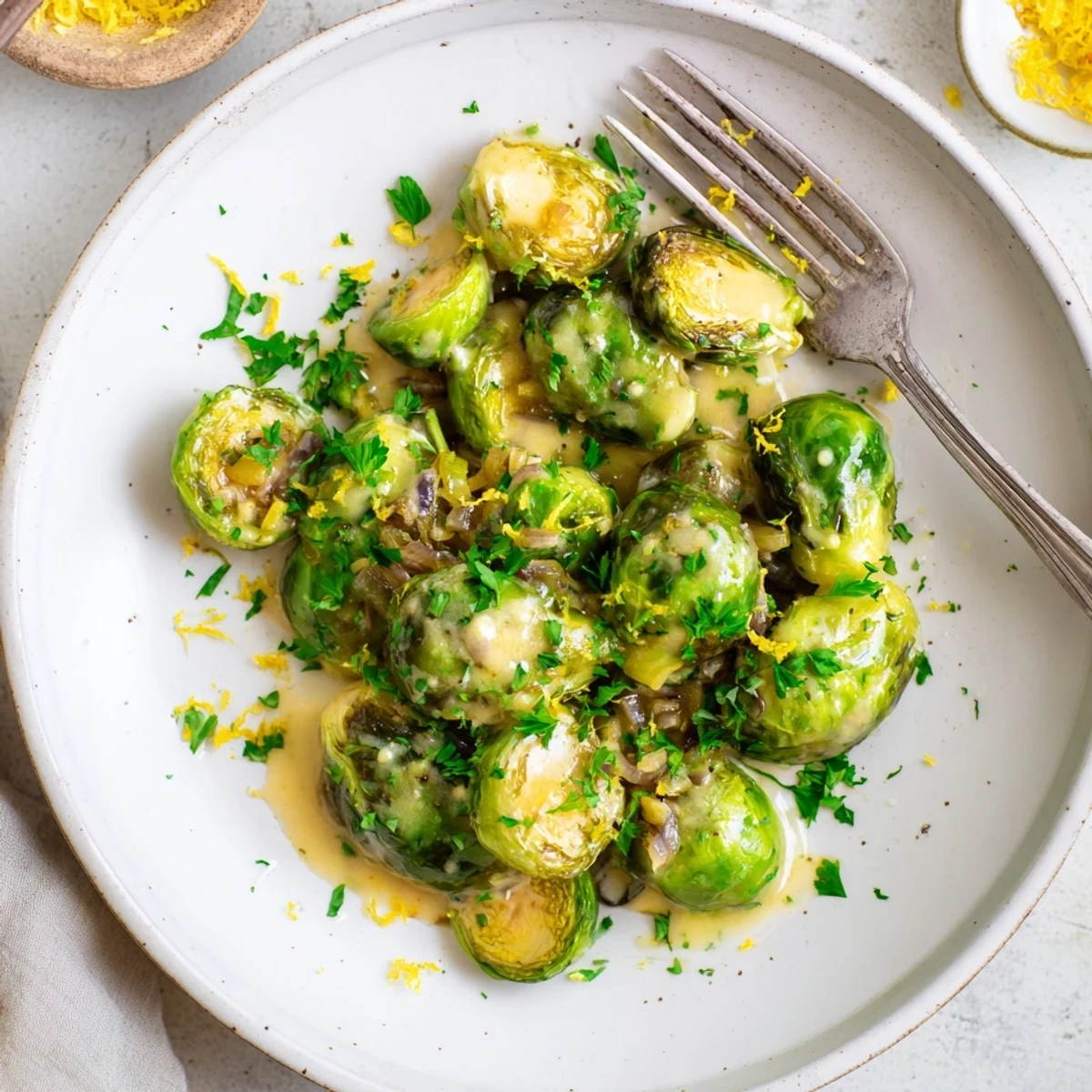 Creamy Boursin Brussels sprouts in a white serving bowl with parsley garnish