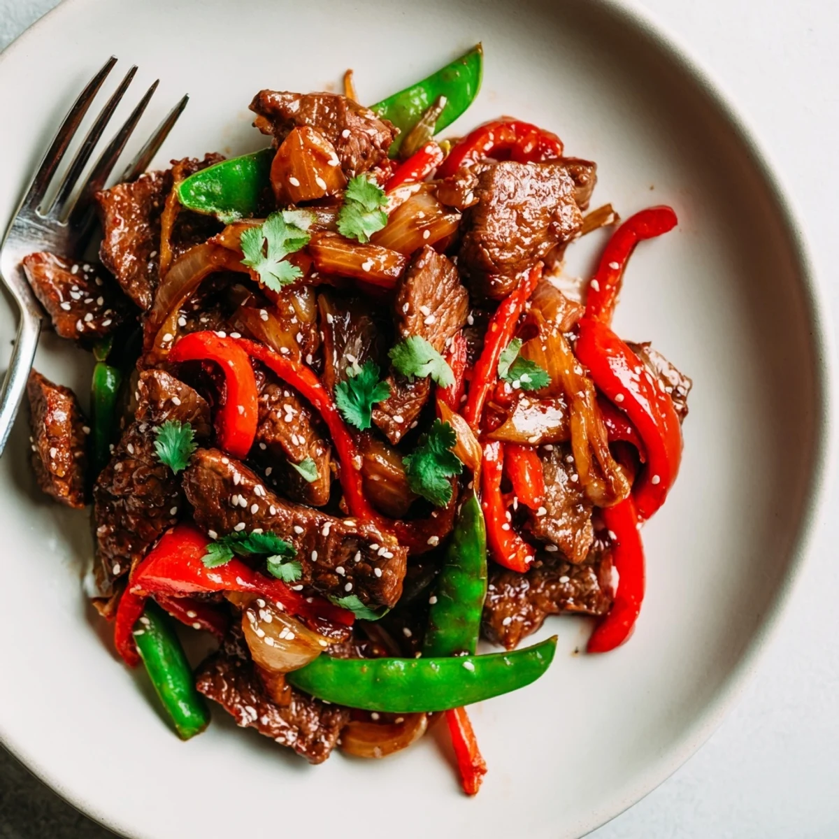 Asian inspired cube steak glistening with soy ginger glaze beside crisp colorful stir fried vegetables