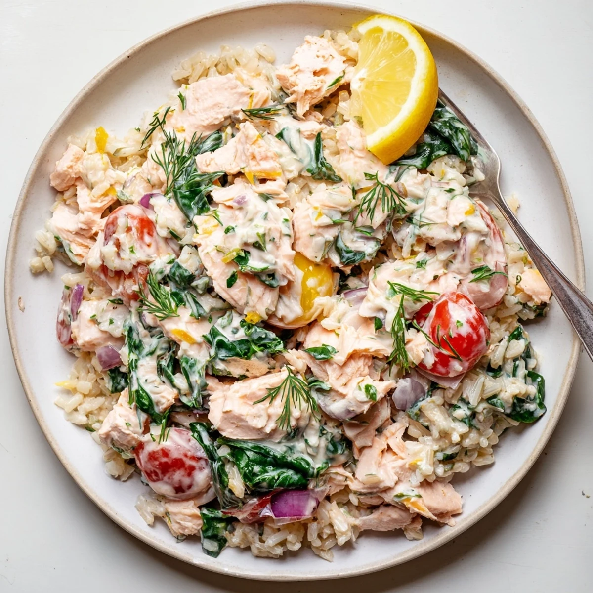 Creamy leftover salmon recipe with bright lemon dill sauce and wilted spinach