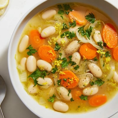 Creamy butter beans and tender carrot slices in golden savory vegetable broth