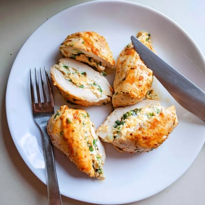 Juicy goat cheese chicken breast sliced open to reveal a creamy herb filling