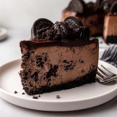 Rich chocolate Oreo cheesecake with a dark cookie crust on a dessert plate